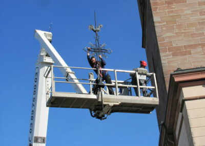 Une nacelle descent la croix de l'eglise