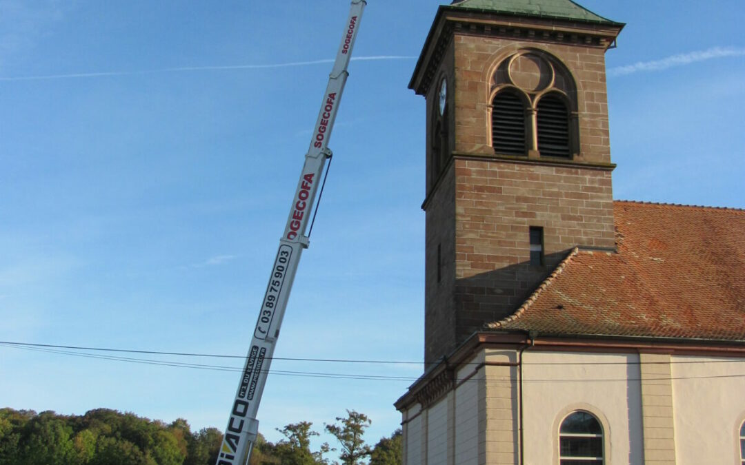 La croix de l'eglise est démontée avec une grande nacelle.