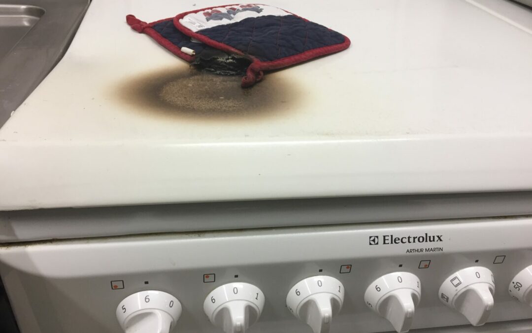 un gant laissé sur une plaque chauffante allumée commence à prendre feu