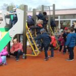 des enfants jouent sur la nouvelle aire de jeux de l'école maternelle